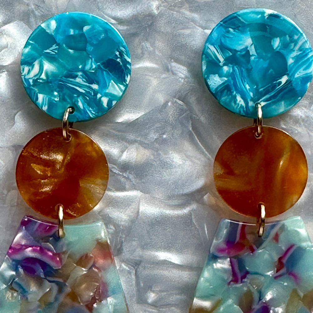 woman wearing Acrylic Circle fan drop earring in blue, orange and purple 