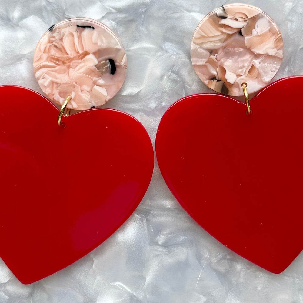 Close up of Acrylic Heart Earrings in At First Blush, red and pink 