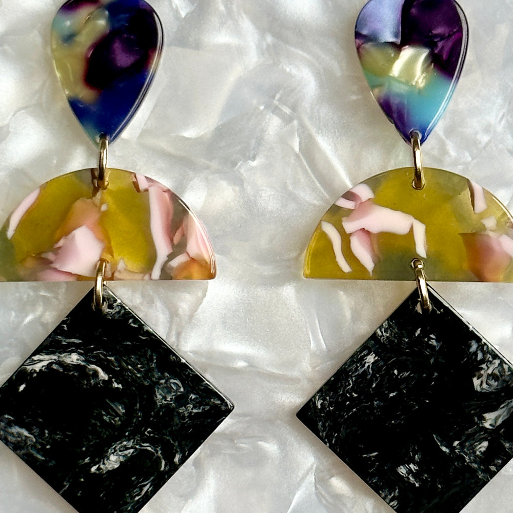 woman wearing Acrylic Hemisphere drop earrings in a mix of black, white, pink, blue and yellow