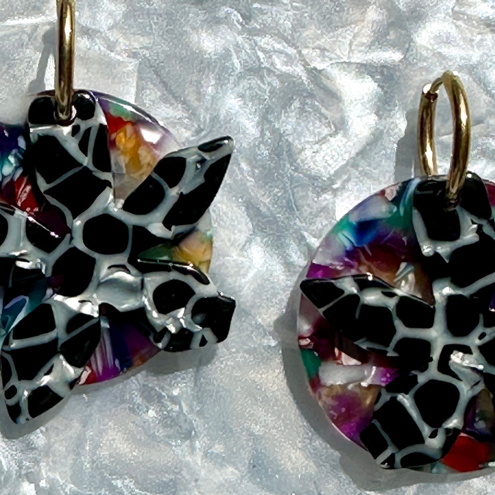 Close up of Acrylic convertible hoop earrings in a mix of black and multicolor 