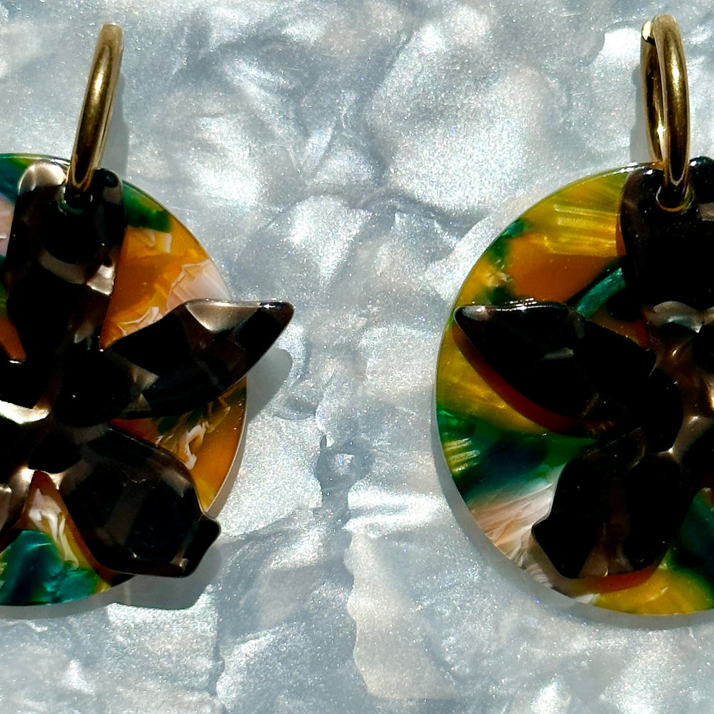 woman wearing Acrylic convertible hoop earrings in a mix of black, green, brown and orange