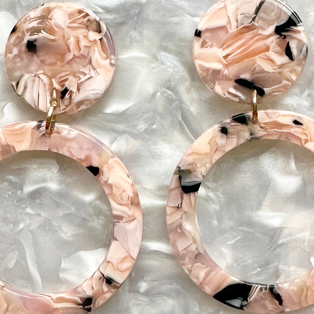 woman wearing Acrylic open circle drop earrings in pink and black 