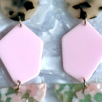 Close up of acrylic Pendulum Drop Earrings in Keepin' It Wheel, green, pink, black and white tortise 