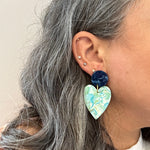 Woman wearing Acrylic Heart Earrings in Sage You Love, green, light blue, navy and white 