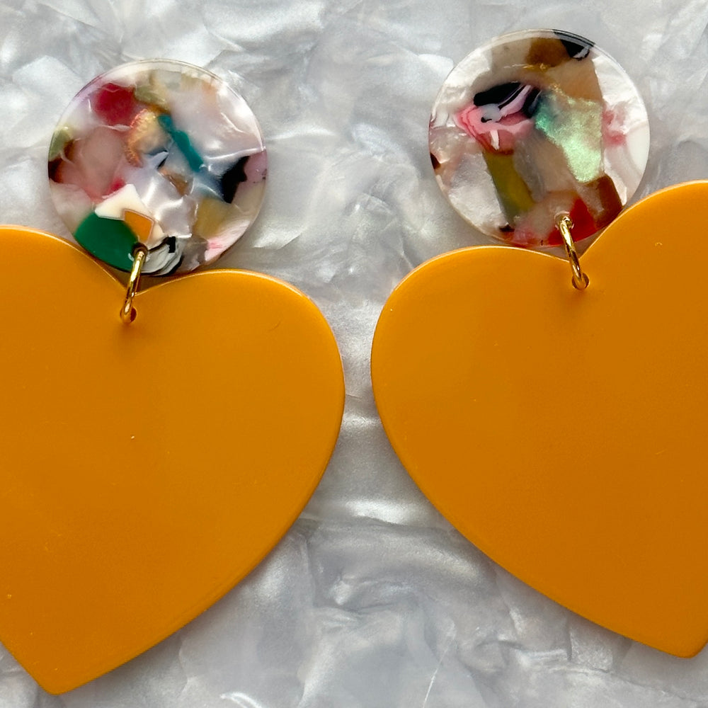 close up of Acrylic Heart Earrings in Miss-behaving, Yellow and light multicolor 