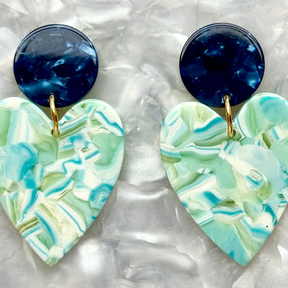 close up of Acrylic Heart Earrings in Sage You Love, green, light blue, navy and white 