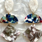 woman wearing Acrylic Hemisphere drop earrings in gray, white and dark blue 