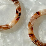 close up of Acrylic Hoop Earrings in cream and brown