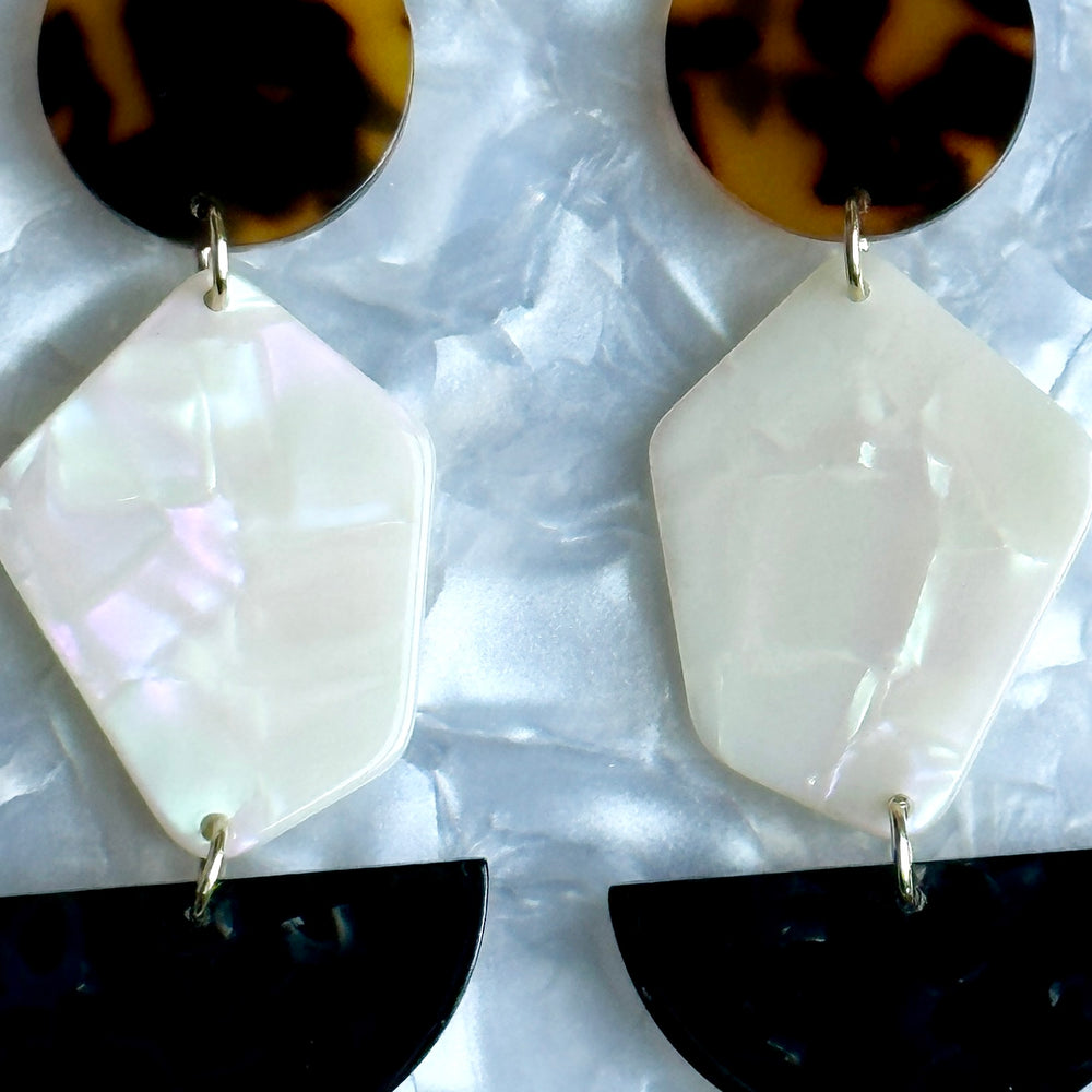 close up of Acrylic Pendulum Drop Earrings in Chic Into The Night, black, brown, and white