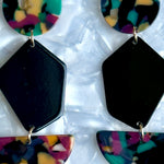 woman wearing Acrylic Pendulum Drop Earrings in Masquerade Belle, black, red, yellow, and green 