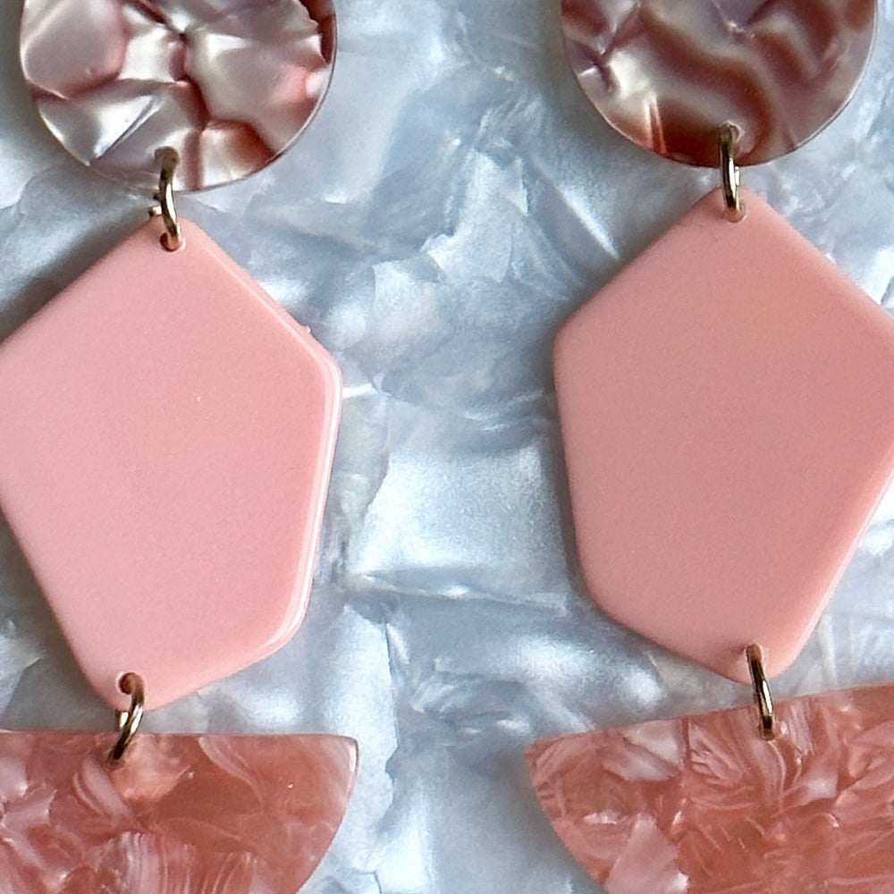 close up of Acrylic Pendulum Drop Earrings in peachy pink and brown mix