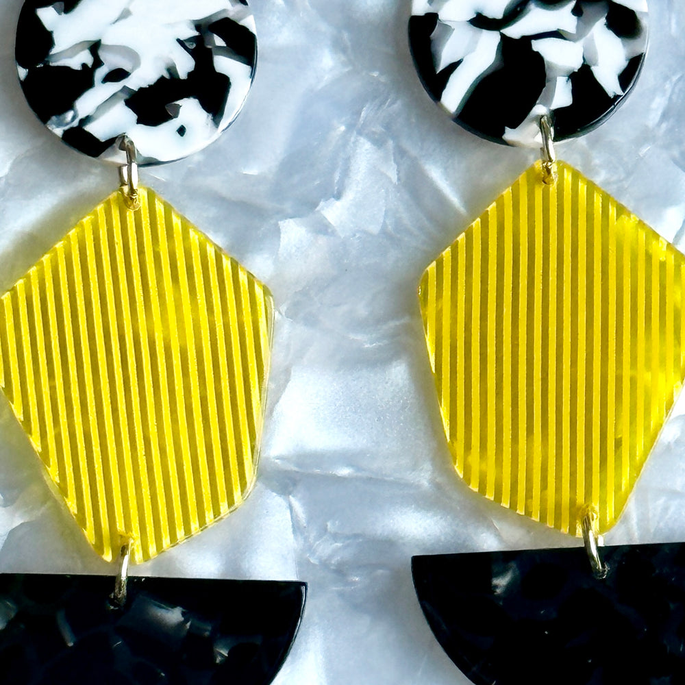 woman wearing acrylic Pendulum Drop Earrings in yellow, black and white 