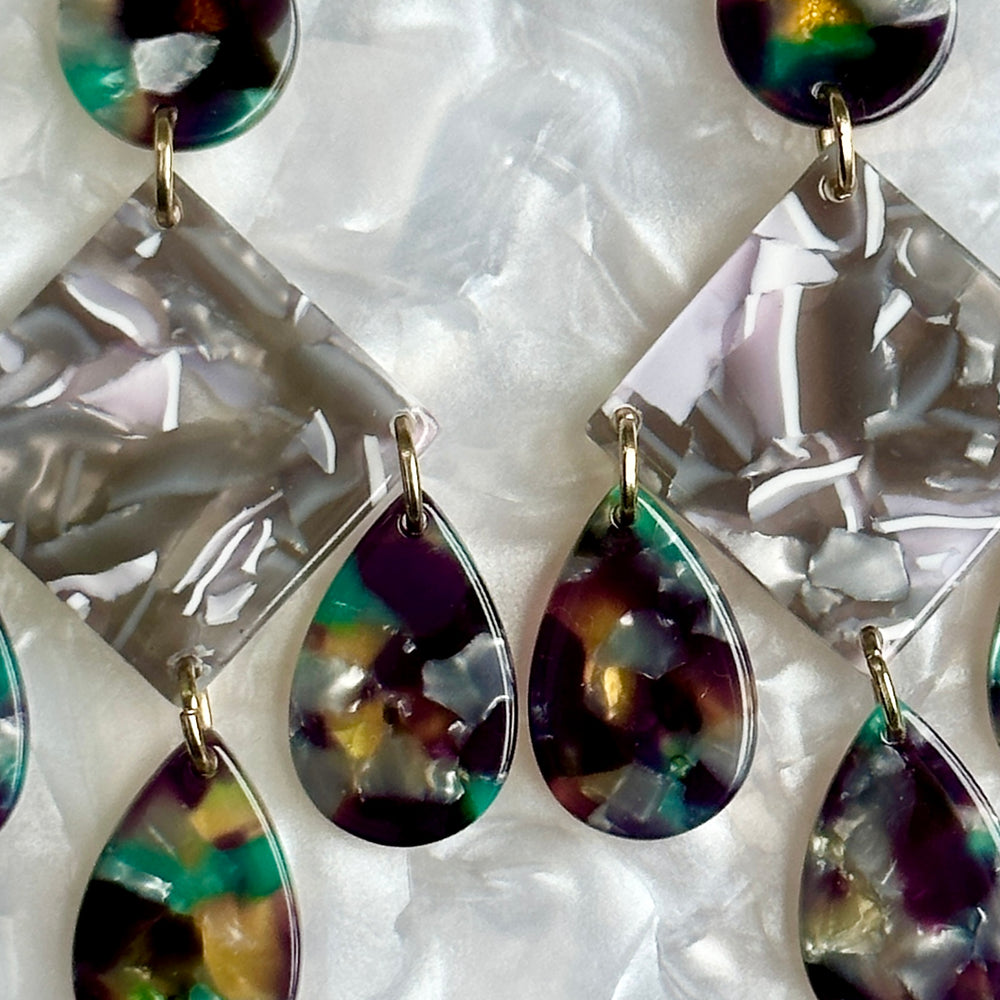 woman wearing acrylic Chandelier Drop Earrings in gray, yellow, purple and green