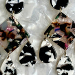 woman wearing acrylic Chandelier Drop Earrings in multicolor, black and white