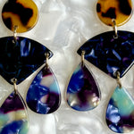 woman wearing acrylic Chandelier Drop Earrings in tortoise navy, blue and purple