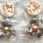 close up of acrylic Flower Drop Earrings in light pink and gray