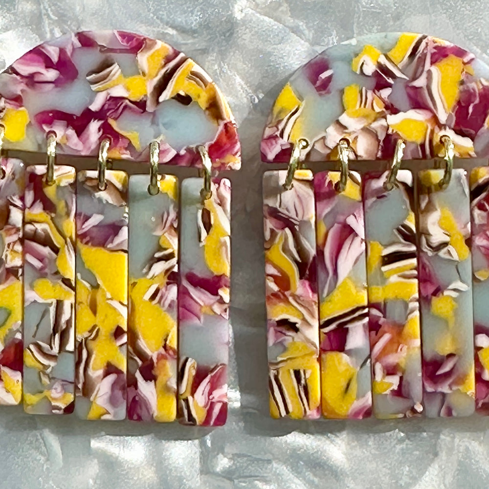 close up of acrylic Fringe Earrings in lilac, magenta and yellow