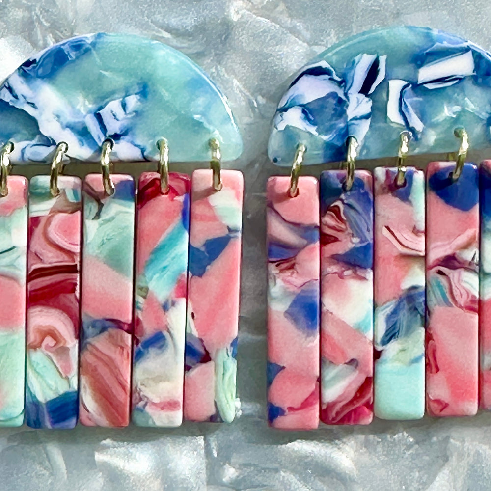 close up of acrylic Fringe Earrings in pink and blue