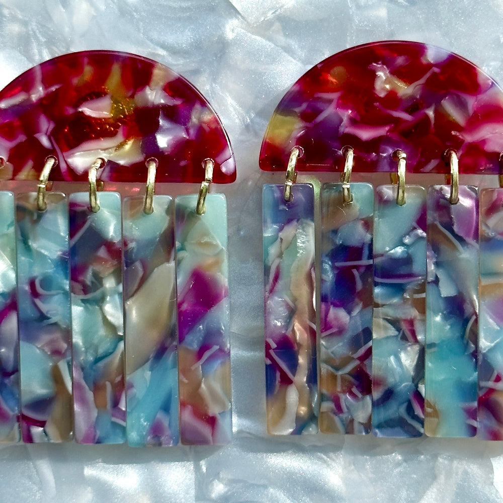 close up of acrylic Fringe Earrings in pink, blue, and purple