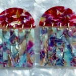 close up of acrylic Fringe Earrings in pink, blue, and purple