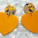 close up of acrylic Heart Earrings in Pencil Me In, yellow, black, lilac, and green 