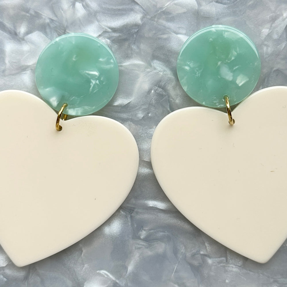 close up of acrylic Heart Earrings in Sweet Heart, cream and teal green 