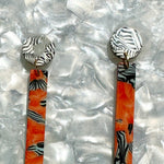 close up of acrylic Matchstick Drop Earrings in Safari Sunrise orange, black and white