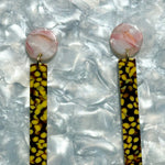 close up of acrylic Matchstick Drop Earrings in pink, brown, and yellow