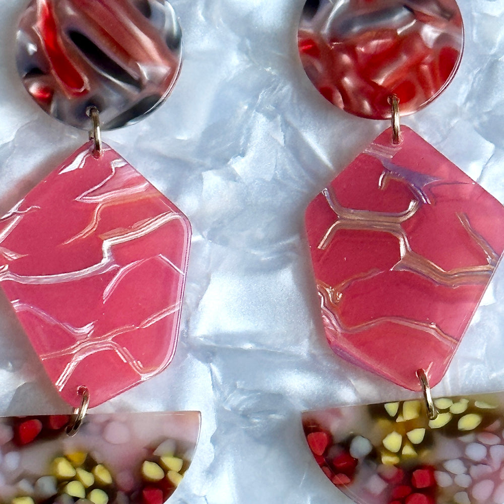 close up of acrylic Pendulum Drop Earrings in Love Yourself To Peaces, red, yellow and blue 