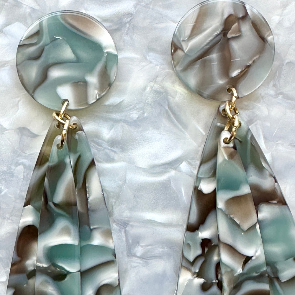 woman wearing acrylic flower Petal Drop Earrings in Abalone gray and green