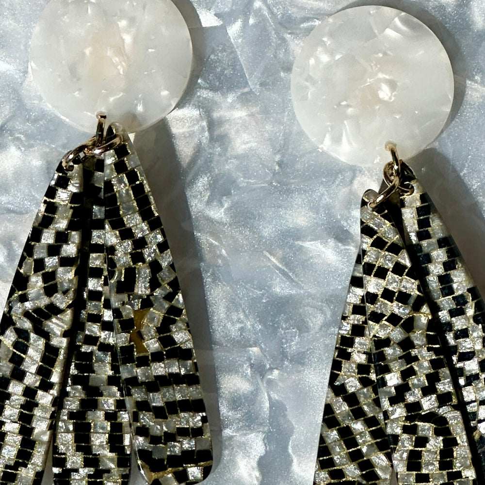 close up of acrylic flower Petal Drop Earrings in black and white checker