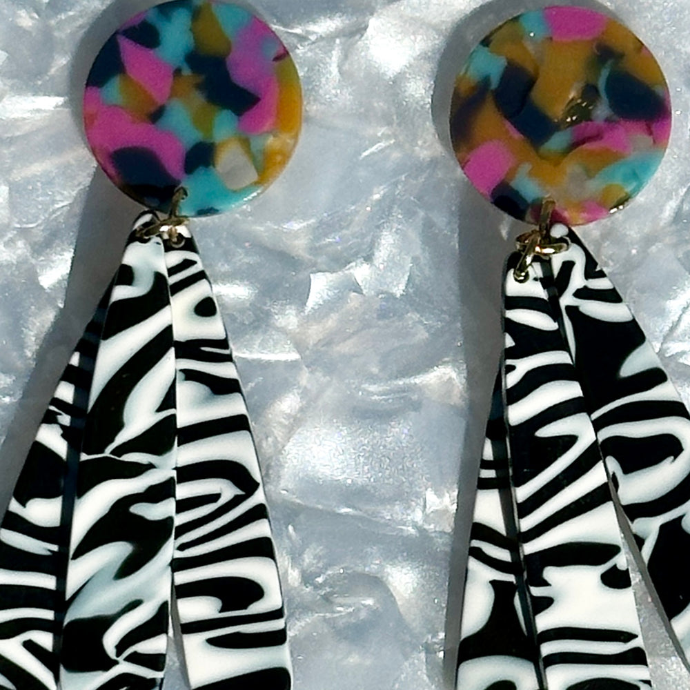 close up of acrylic flower Petal Drop Earrings in black and white stripe with blue, yellow and pink