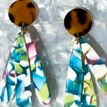 close up of acrylic flower Petal Drop Earrings in pink, white, green and blue with tortoise