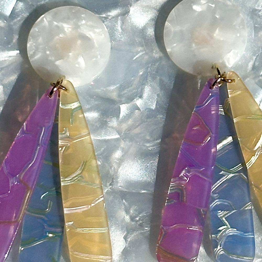 close up of acrylic flower Petal Drop Earrings in white, purple, blue and yellow