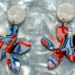 woman wearing acrylic flower earrings in freedom red, white and blue