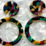 woman wearing acrylic open circle drop earring in dark red, green, yellow, and Black 