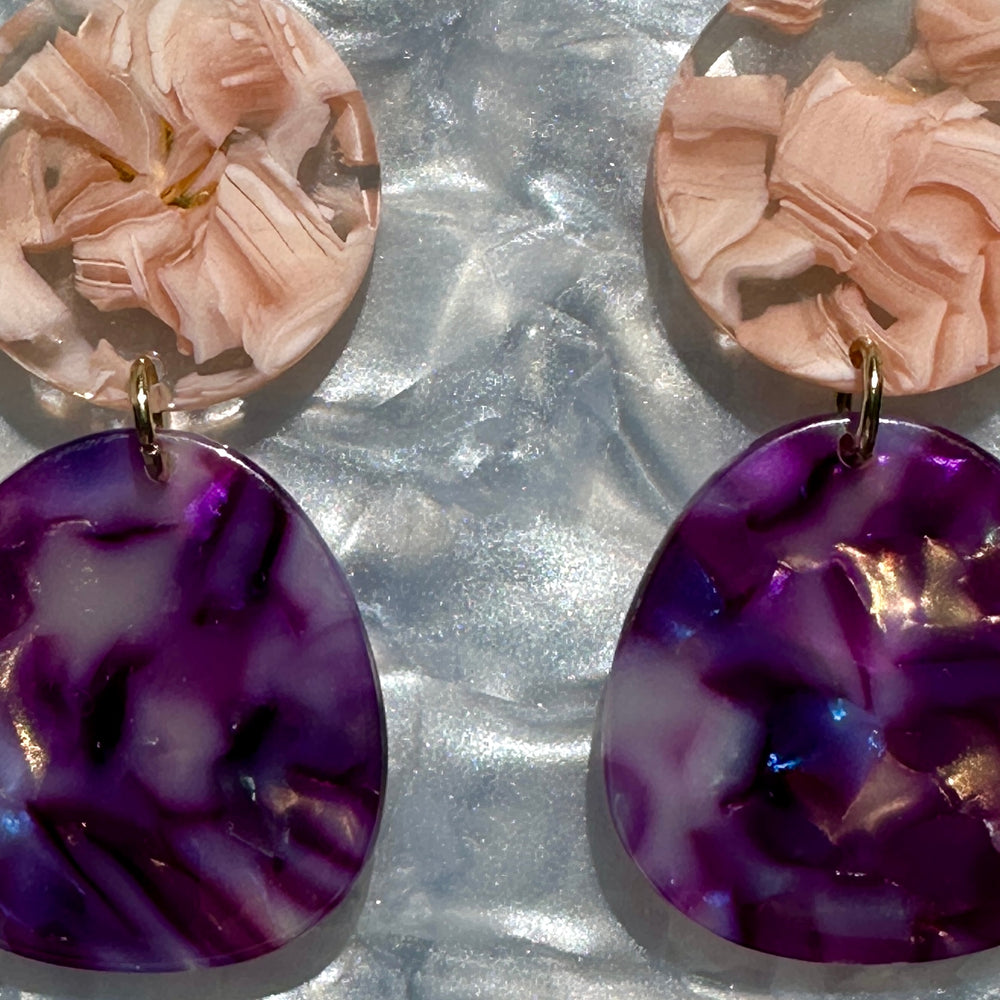 woman wearing a acrylic organic circle drop earring in light pink and purple 