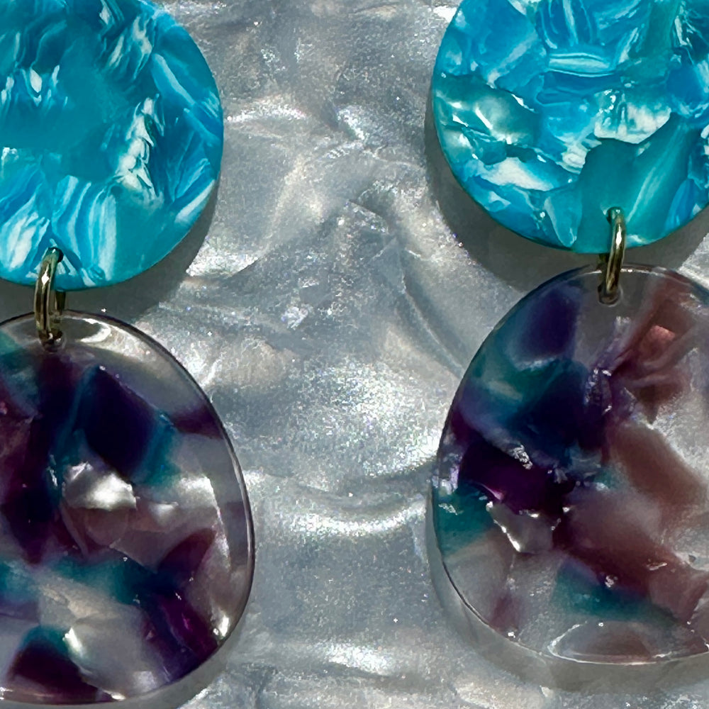 close up of acrylic organic circle drop earring in purple and blue 