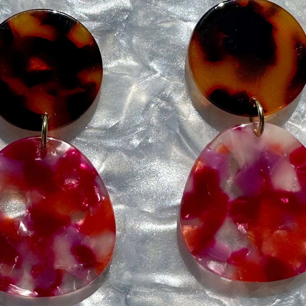 woman wearing acrylic organic circle drop earring in tortise, pink and orange