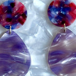 close up of acrylic teardrop earrings in purple and red