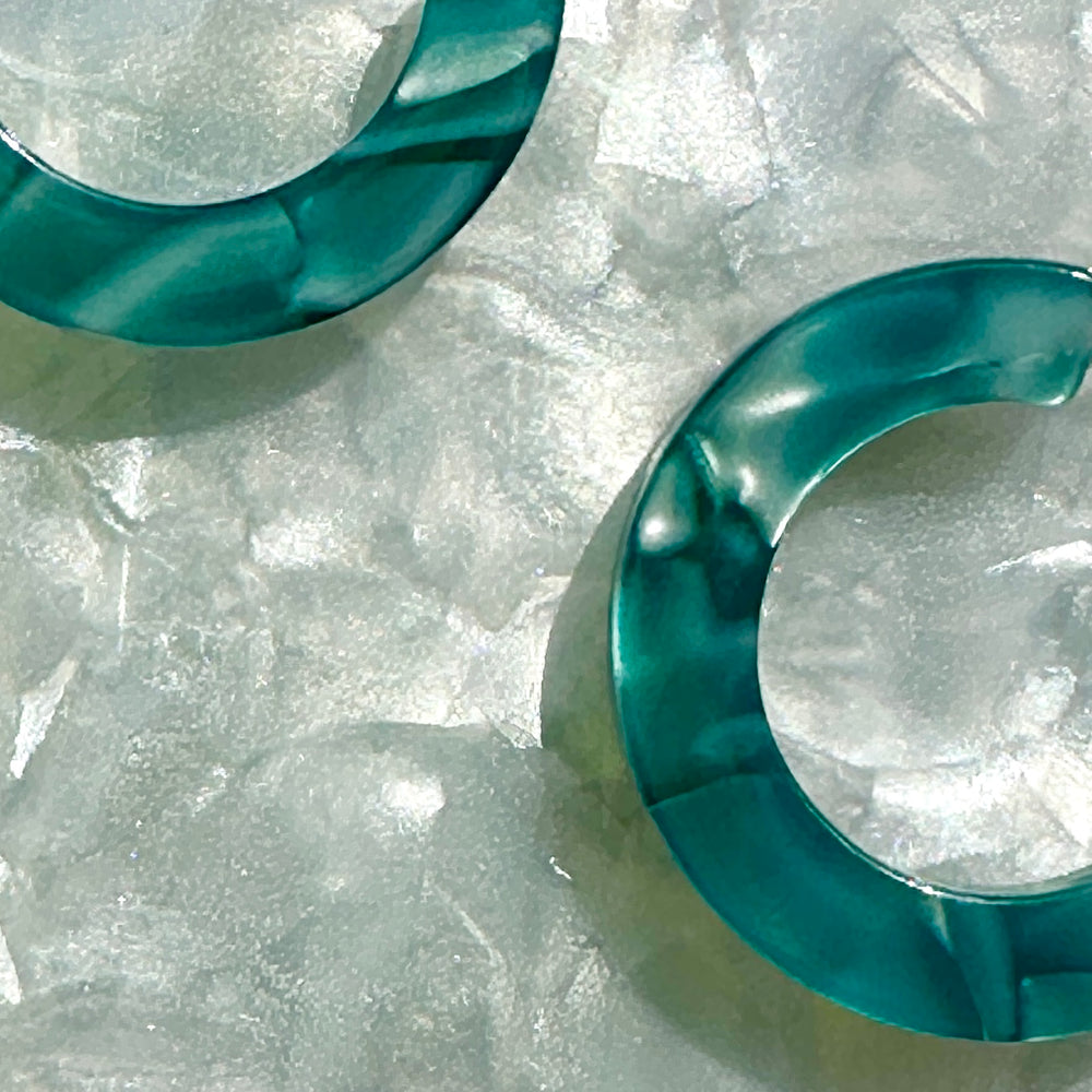 close up of mini acrylic hoop earrings in blue 