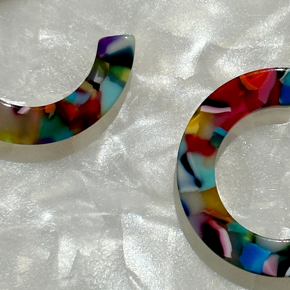 close up of mini acrylic hoop earrings in multicolor