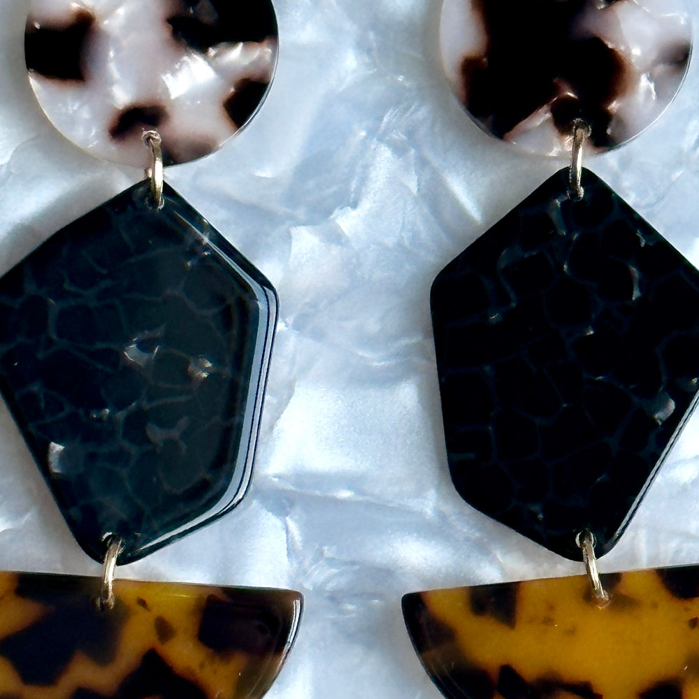 close up of woman wearing Acrylic Pendulum Drop Earrings in blonde tortoise, black and tortoise 