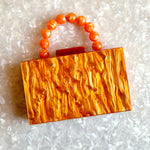 clutch purse with beaded handle in orange acrylic