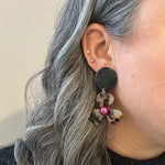 woman wearing Acrylic Flower Drop Earrings in black, purple, and beige