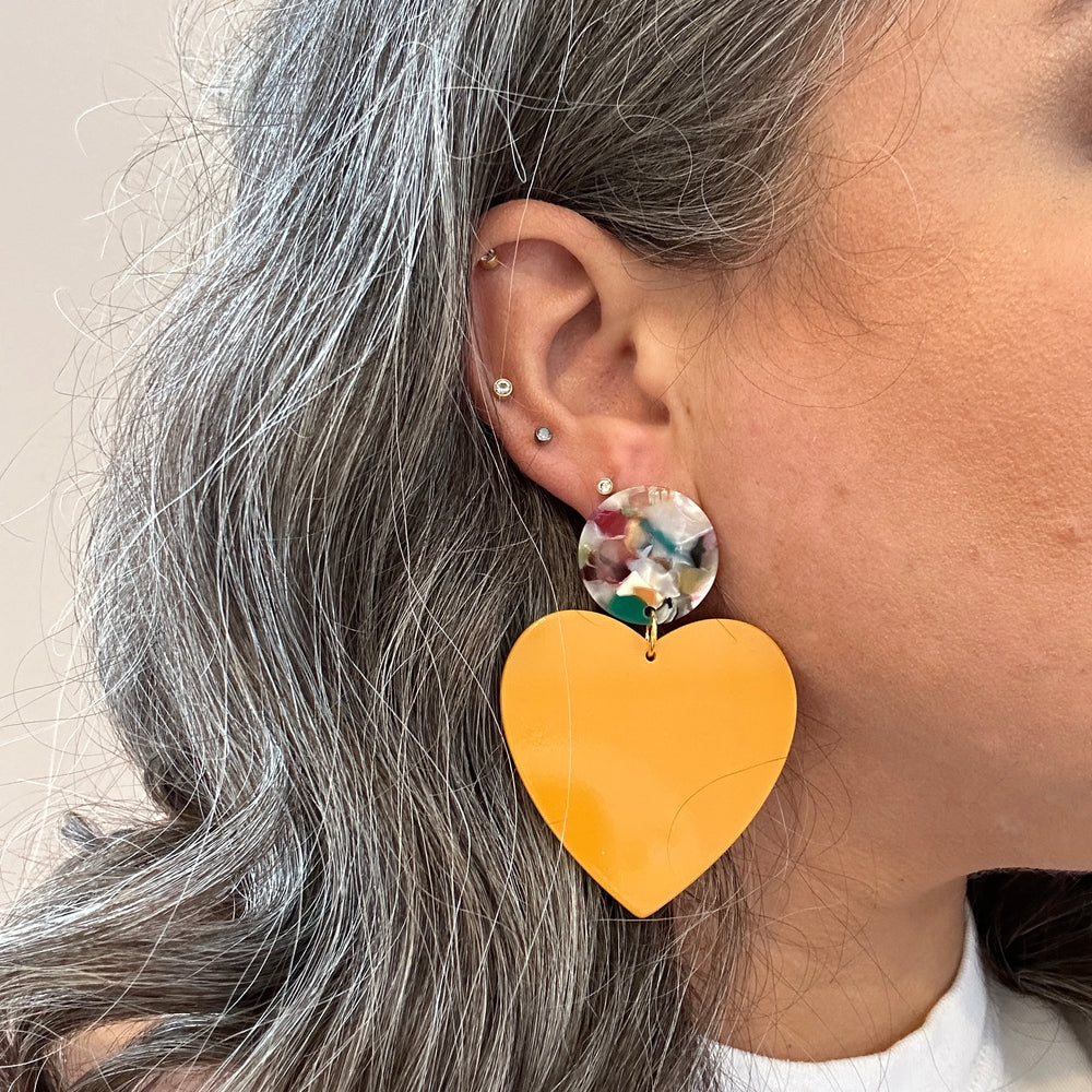 woman wearing Acrylic Heart Earrings in Miss-behaving, Yellow and light multicolor 