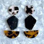 woman wearing Acrylic Pendulum Drop Earrings in blonde tortoise, black and tortoise 