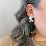 woman wearing Acrylic Pendulum Drop Earrings in blonde tortoise, black and tortoise 