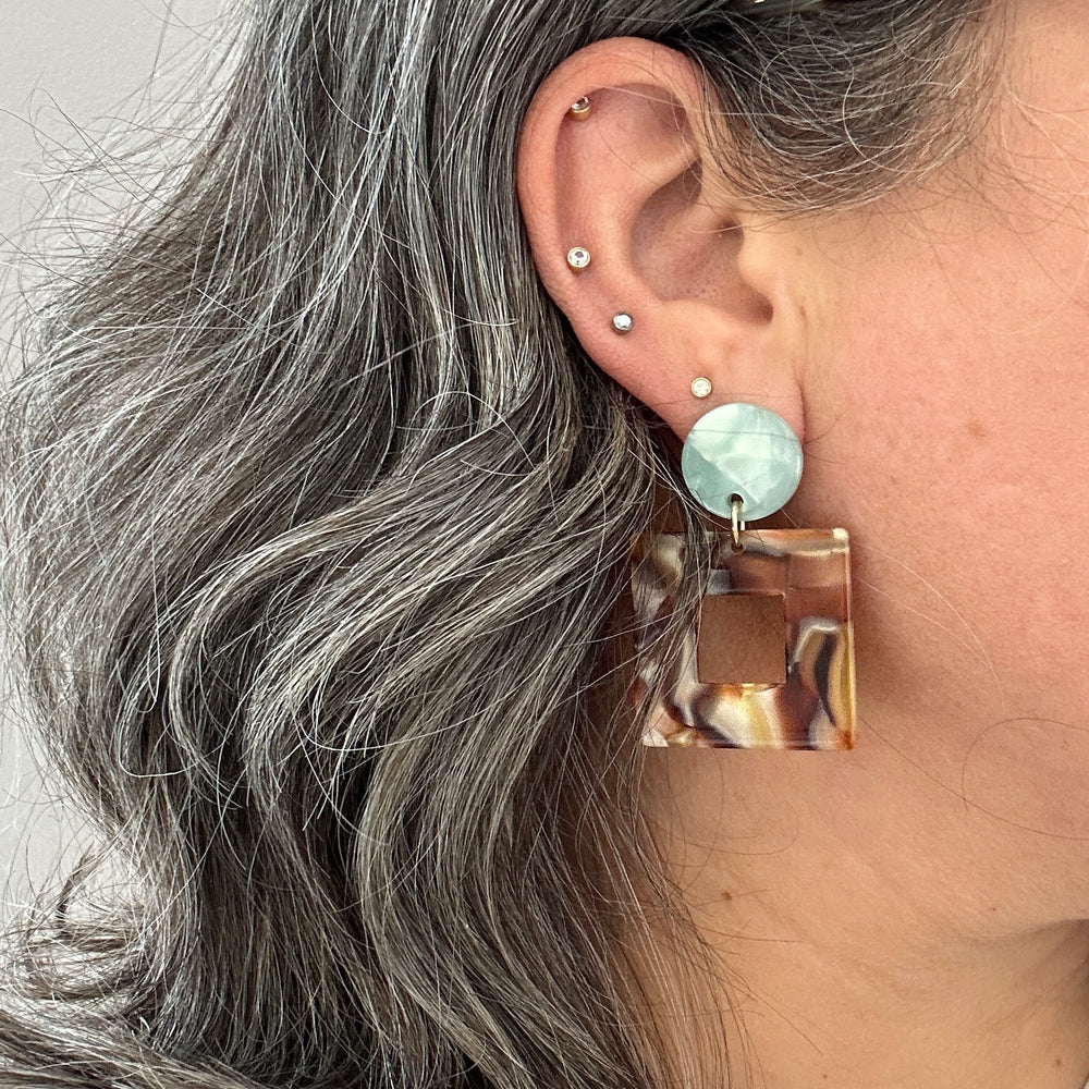 woman wearing Acrylic Square Drop Earrings in Peanut Brittle, brown, lod and teal green 