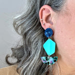 woman wearing Acyrlic Pendulum Drop Earrings in Along For The Vibe, navy blue and teal green 